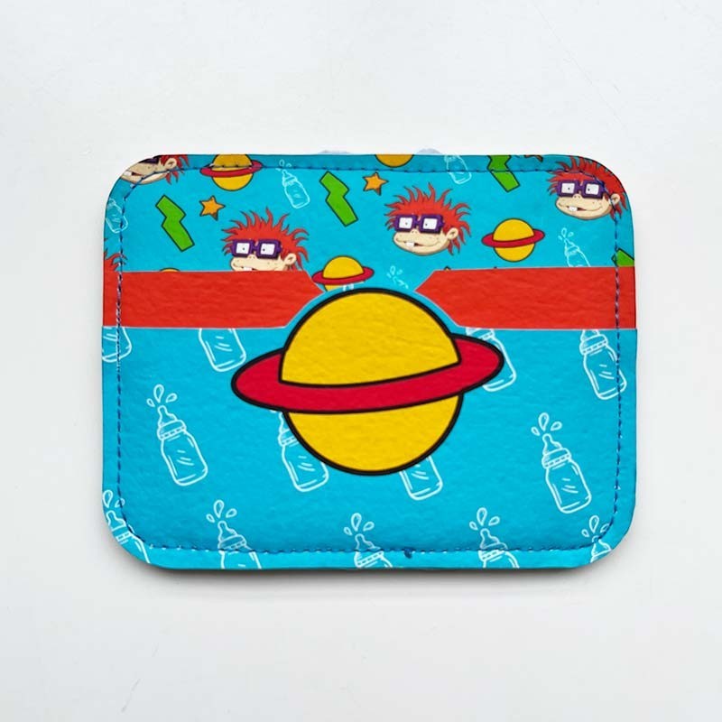 dfpbfriends Rugrats cardholder in blue faux leather with a repeating pattern of Chucky Finster, planets, and baby bottles. Features a red stripe and a yellow planet with a red ring.